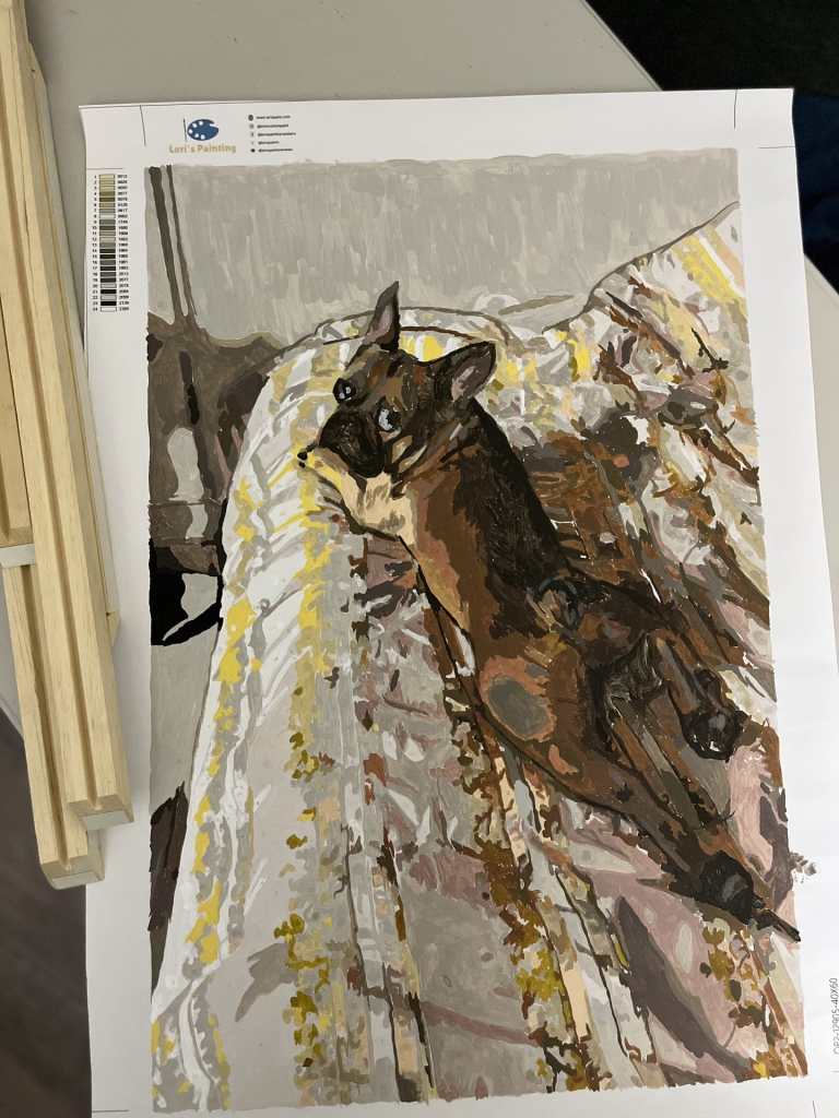 a finished custom paint by numbers painting of a dog laying on a bed